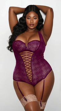 Plus size model wearing Curvy Bombshells Berry Tease Teddy in deep berry lace with crisscross front design.