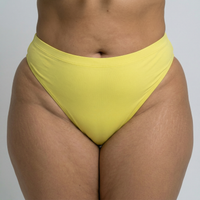 Close-up of Lemon Drop plus size bikini bottom in bright yellow on curvy model in studio