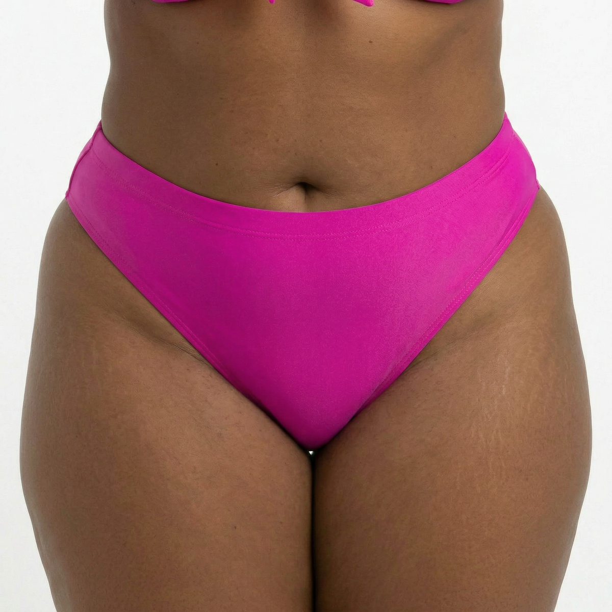 Close-up of Poppin Pink plus size bikini bottom in bold hot pink on curvy model in studio