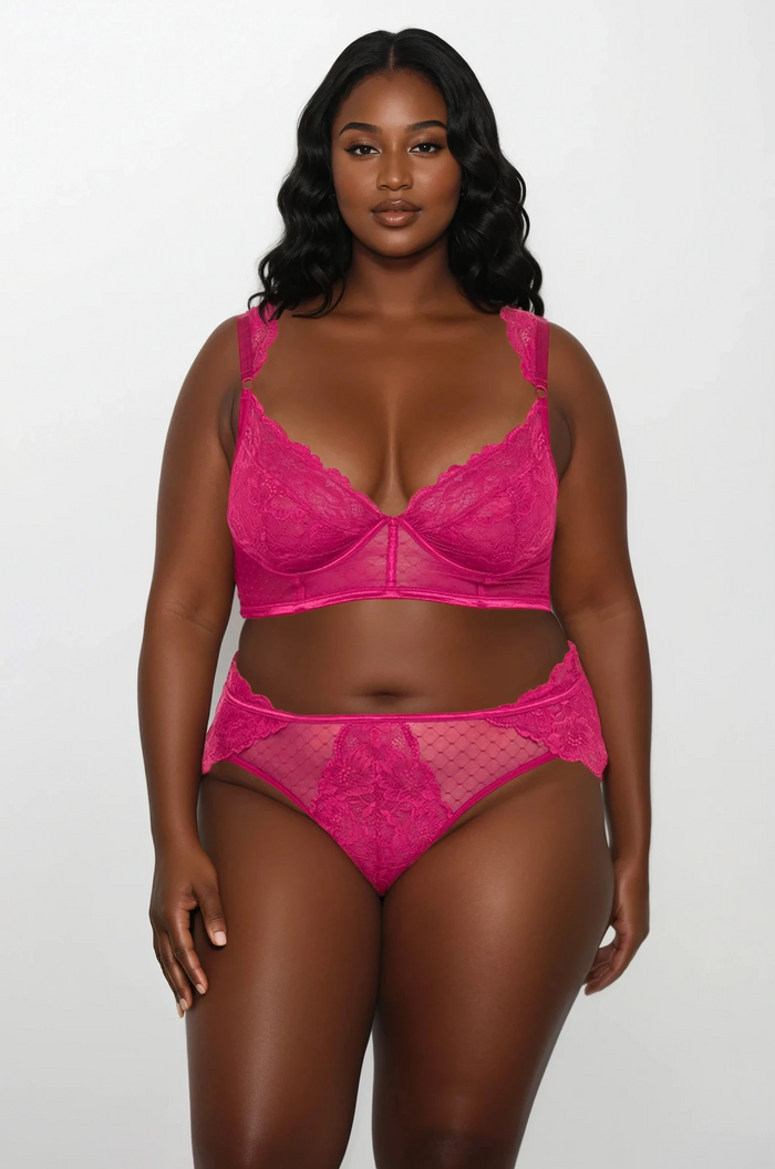 Plus size model wearing pink lace underwire bra set front view with sheer mesh and floral lace details